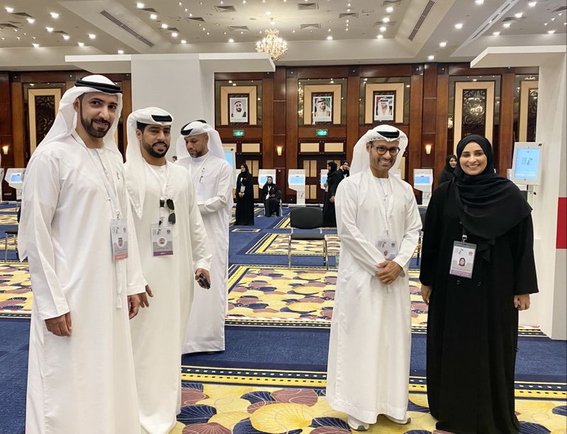 Mohammed Hamad Al Kuwaiti (second from right) and Essa Mohammed Khalifa Al Mutaiwei (first from left) with other officials at Dubai's main voting center at the Dubai World Trade Center during the first-1696690106062