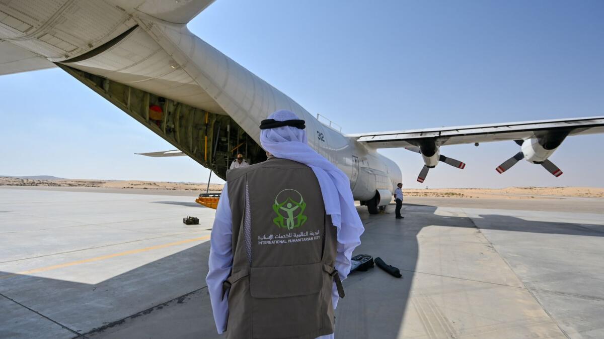 An official from Dubai International Humanitarian City (IHC) monitors relief materials unloaded at Al Arish Air Base.