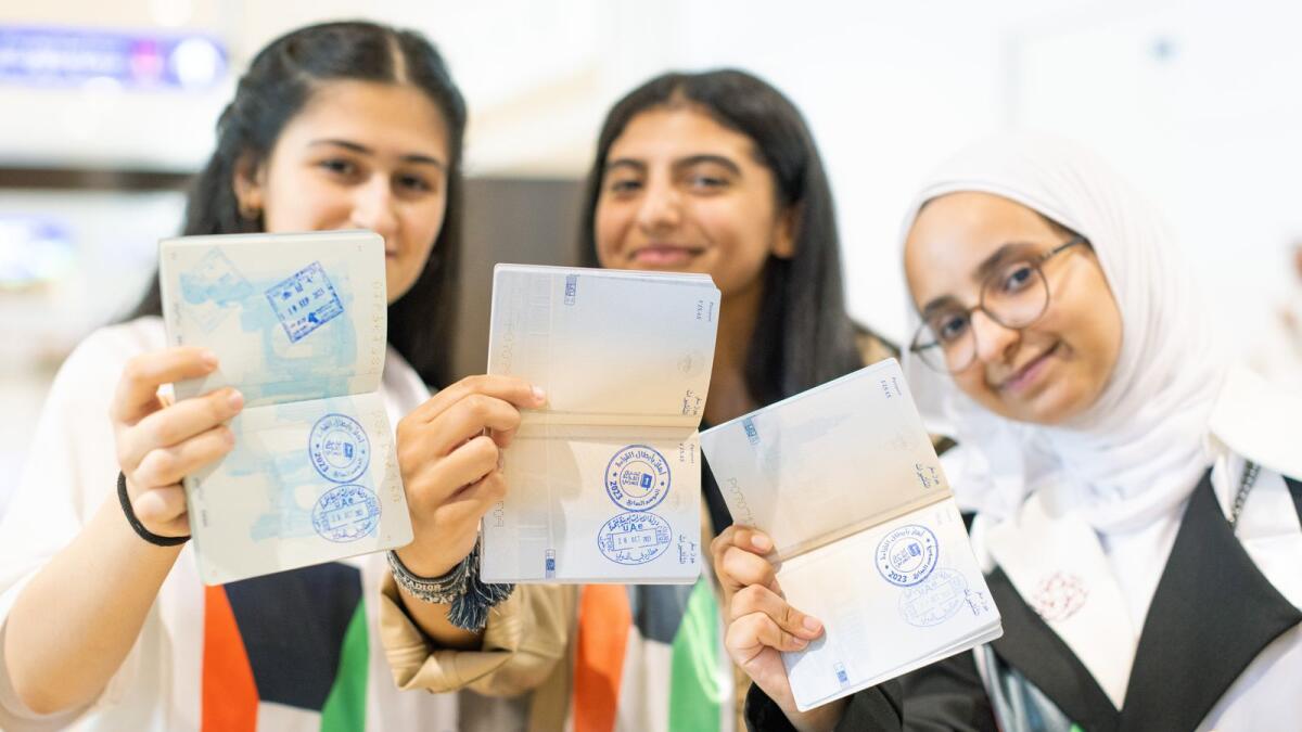Arab Reading Challenge participants display the special entry stamp featuring the Arab Reading Challenge logo in their passports.