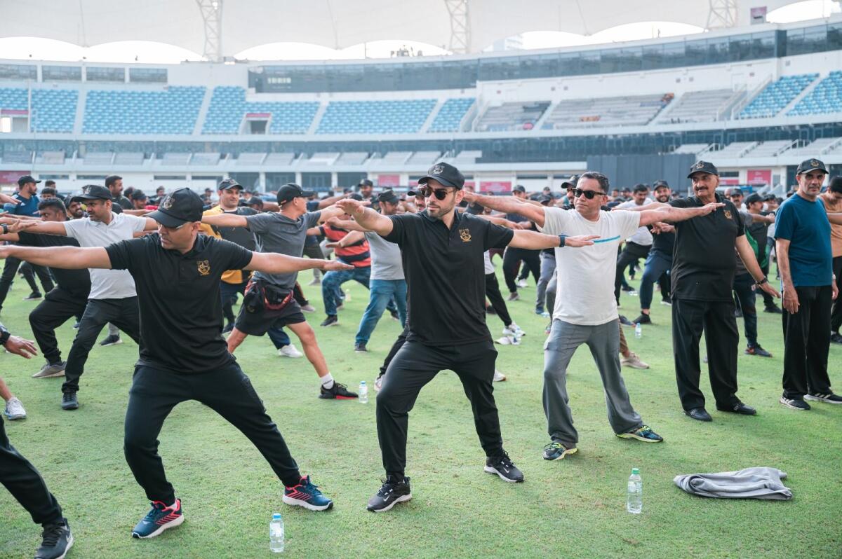 Ibrahim Galadari, group chief investment officer, Ravi Tharoor, executive director of advertising media division, among other employees, participate in the inauguration of the Galadari Fitness Challenge 2023 at the Dubai International Cricket Stadium on Saturday.  Photo by Neeraj Murali