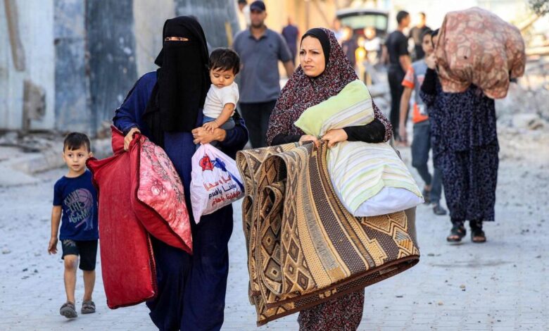 Palestinian women walk with children and their belongings as they flee an area following an Israeli airstrike in Rafah, southern Gaza Strip, on October 13.  – AFP