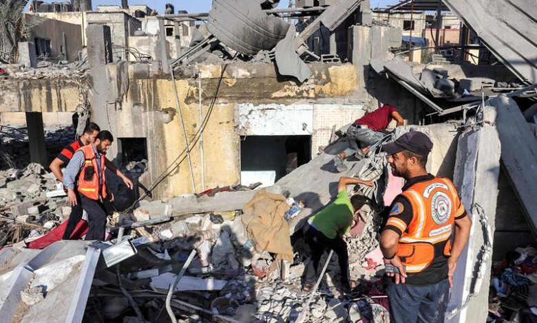 Palestinian civil defense rescuers search through the rubble of a building after an Israeli airstrike in Rafah, southern Gaza Strip, October 13, 2023.