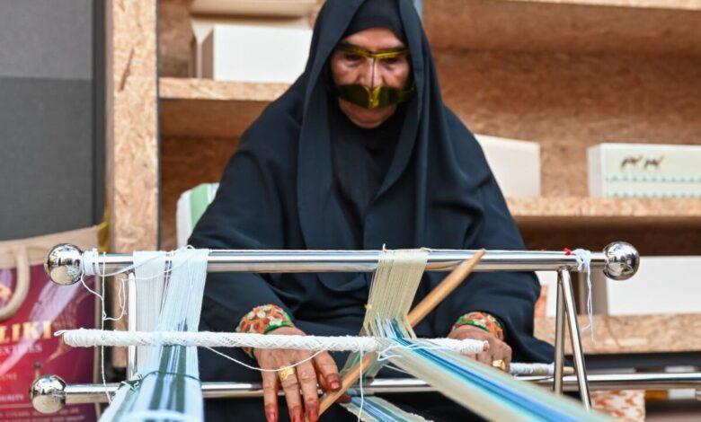 Emirati woman dressed in burka'a shows a traditional form of weaving.  KT Photos: Muhammad Sajjad