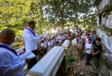 Catholic lay ministers say a prayer during the mass burial of victims of the Masara landslide, at Mawab, Davao de Oro, Philippines.