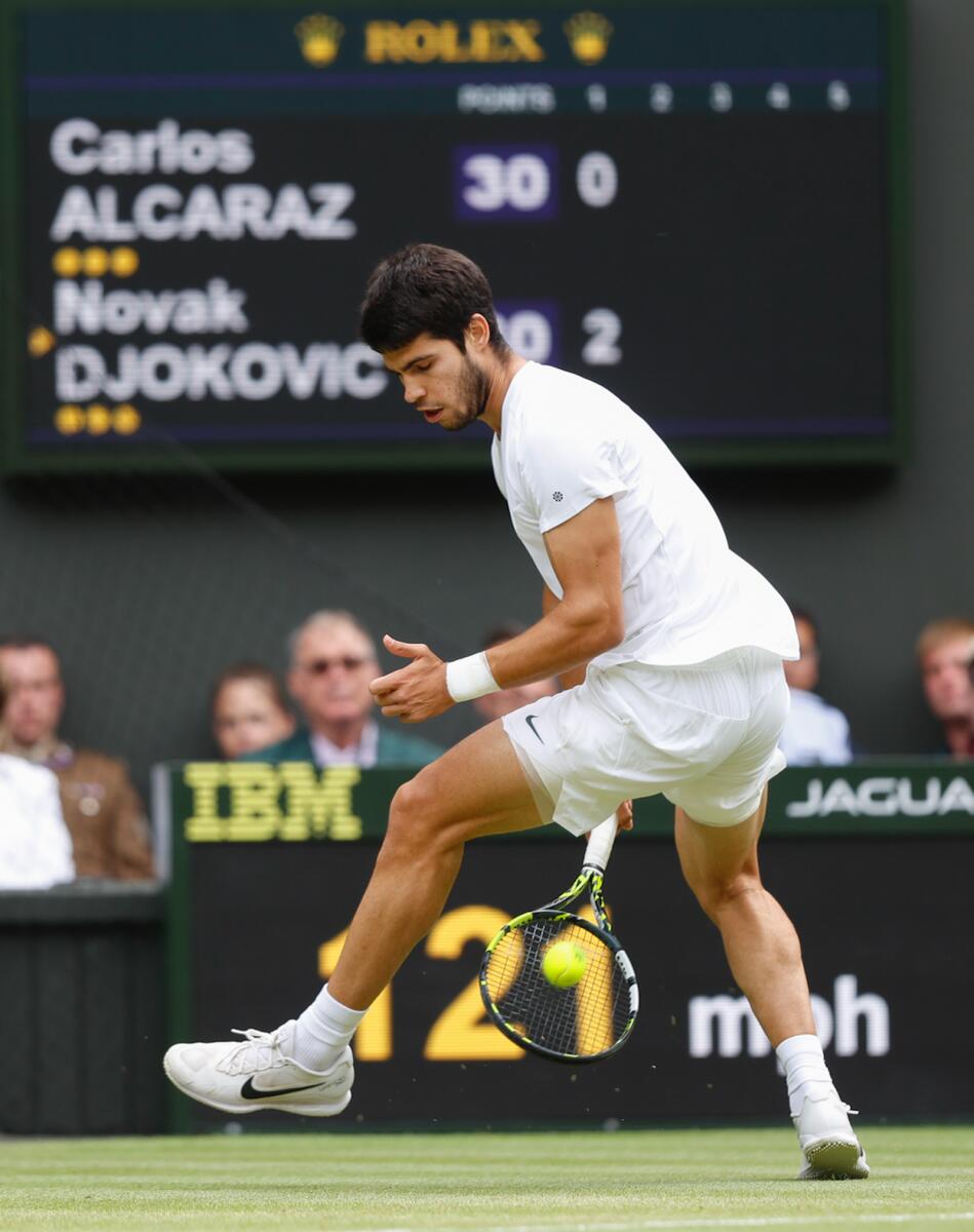 Carlos Alcaraz performs a tweener (shot between the legs with his back to the net) against Novak Djokovic in the 2023 Wimbledon final. — Tennis and travel photographs courtesy of Juergen Hasenkopf