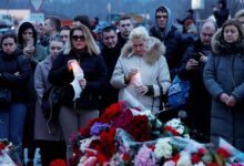 People gather at a makeshift memorial to the victims of a shooting attack set up outside the Crocus City Hall concert venue outside Moscow on March 23, 2024.