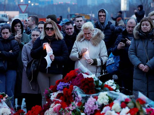 People gather at a makeshift memorial to the victims of a shooting attack set up outside the Crocus City Hall concert venue outside Moscow on March 23, 2024.